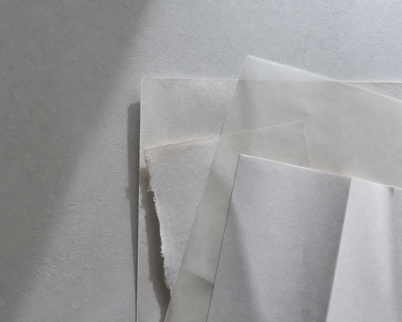 Layered archival paper and translucent vellum in soft window light